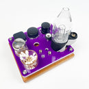 Your Focus V Carta vaporizer will nestle securely in this mini rig station. Tray has openings to hold 3 wax concentrate jars as well as extra buckets and carb caps. Includes an ISO dispenser and Q-Tip holder. Shown in purple on a cherry base.
